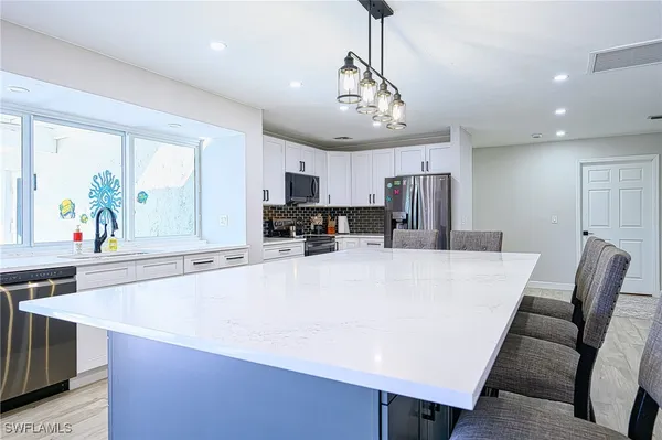 a large kitchen with a table and chairs
