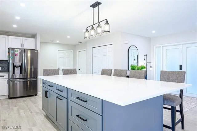 a kitchen with stainless steel appliances kitchen island a chandelier and refrigerator
