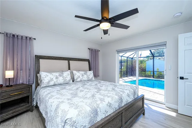 a large bed sitting in a bedroom next to a window with a chandelier