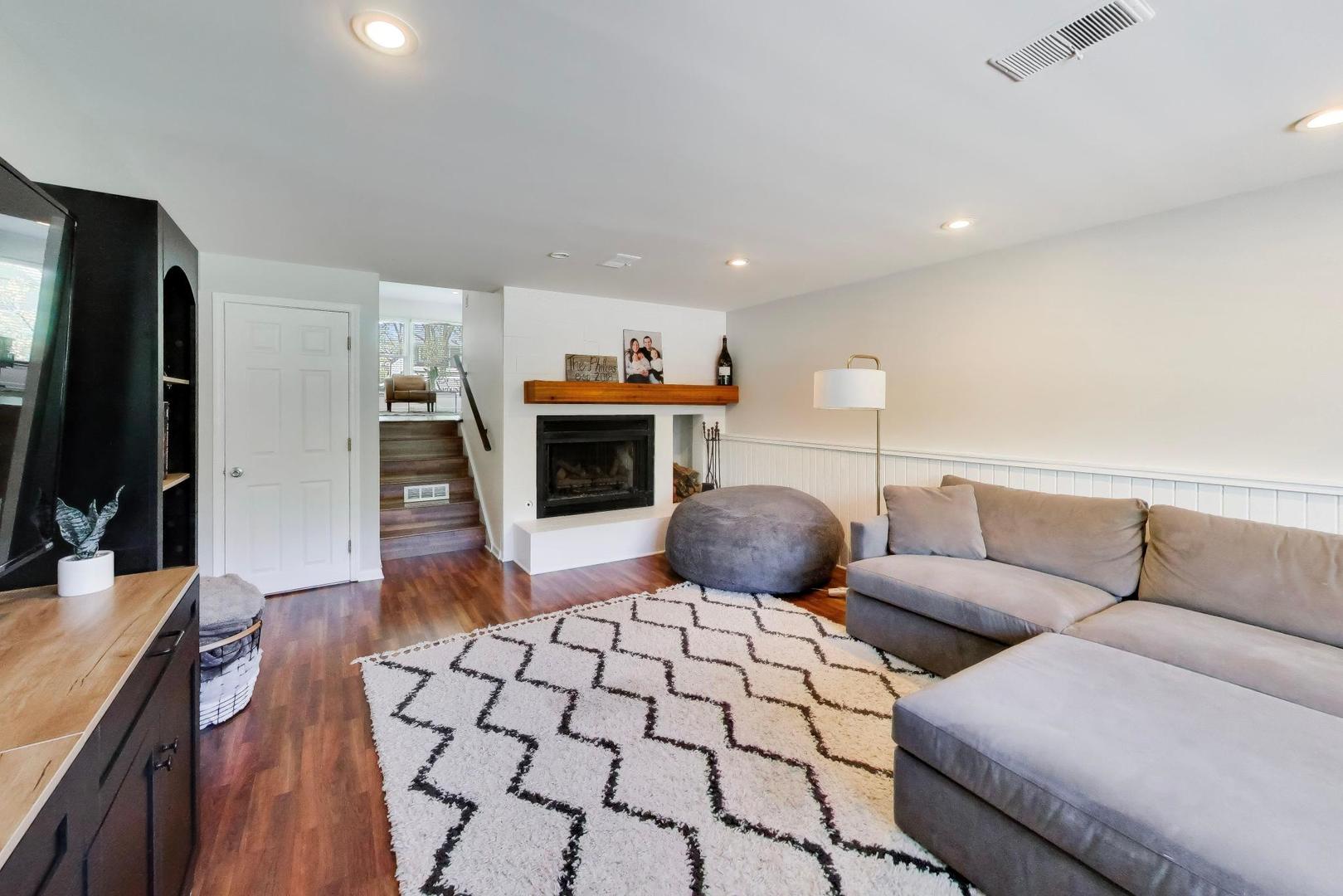 1153 Kenton Road Deerfield, IL 60015 - Photo 24 of 40 a living room with furniture a flat screen tv and a fireplace