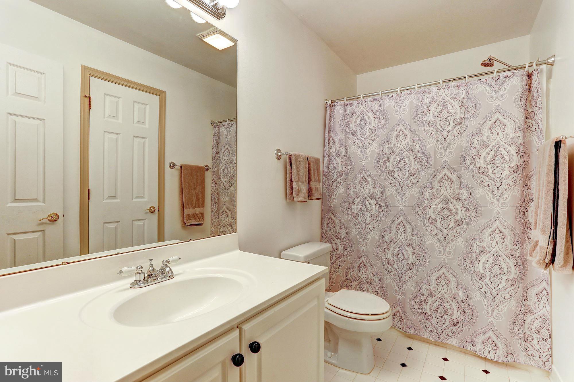 4006 Roop Road New Windsor, MD 21776 - Photo 14 of 22 a bathroom with a sink a toilet and shower curtain
