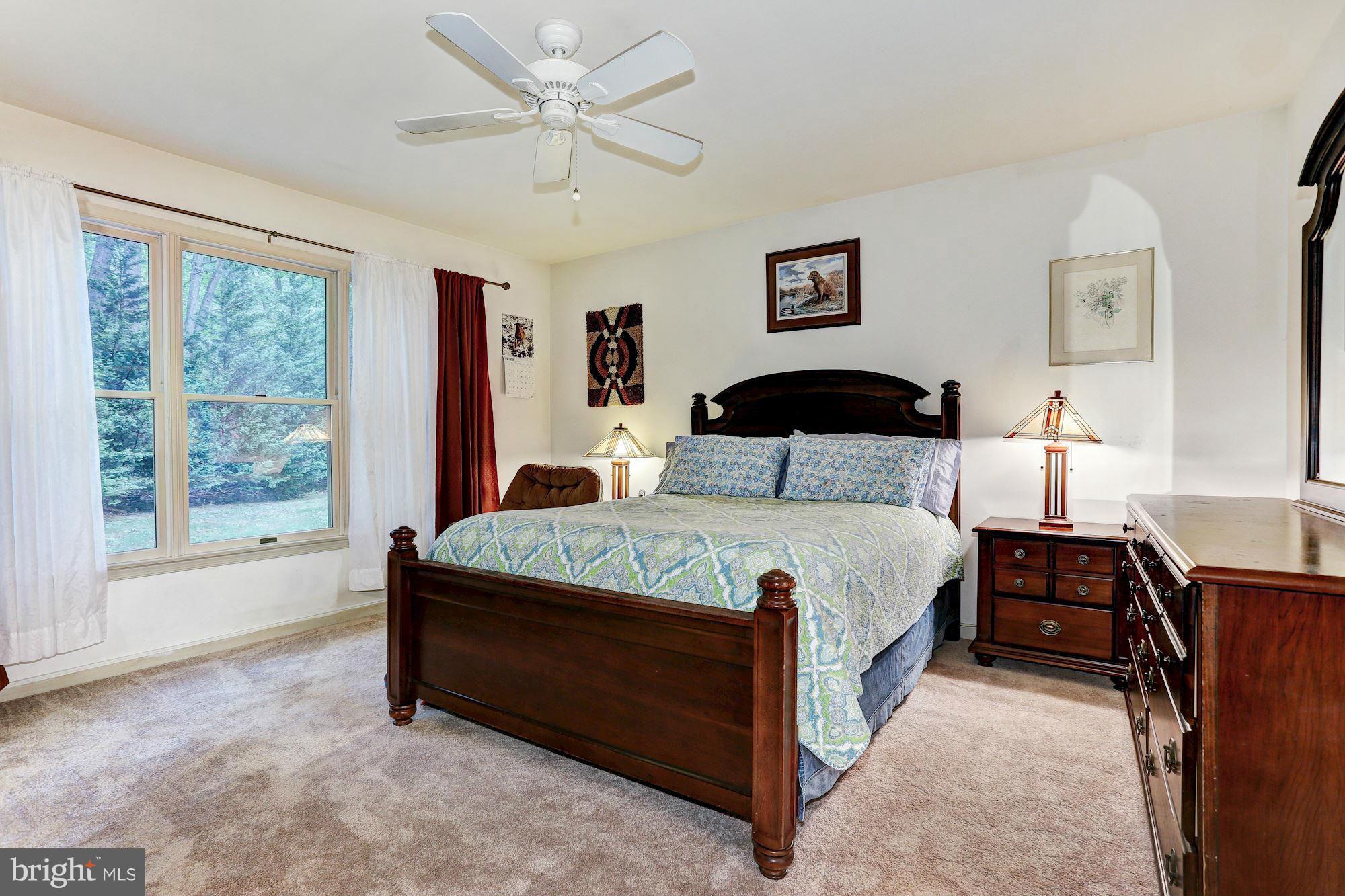 4006 Roop Road New Windsor, MD 21776 - Photo 10 of 22 a bedroom with a bed a table and a large window