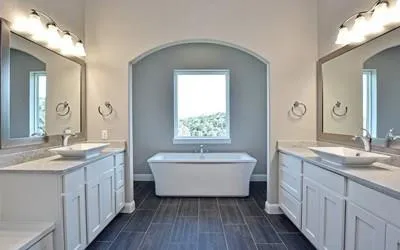 a bathroom with a double vanity sink mirror and bathtub