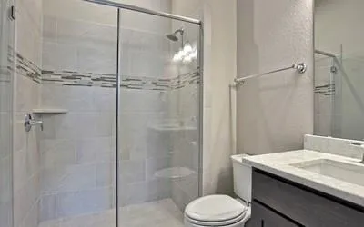 a bathroom with a granite countertop sink toilet and shower
