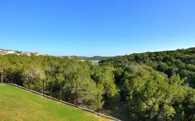a view of a green field with mountains in the background