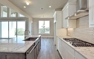 a kitchen with stainless steel appliances granite countertop a sink a stove and a wooden cabinets