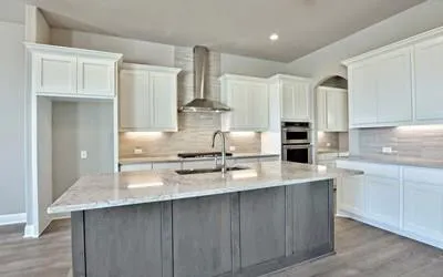 a kitchen with stainless steel appliances a sink stove and white cabinets