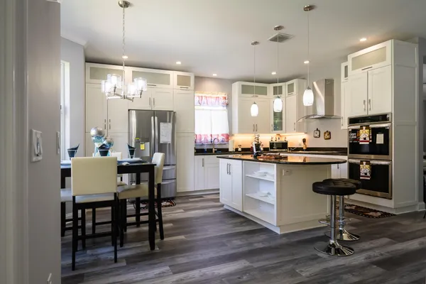 a kitchen with stainless steel appliances granite countertop a stove a sink and a refrigerator