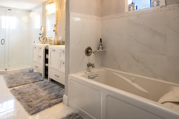 a bathroom with a double vanity sink a mirror a bathtub and shower