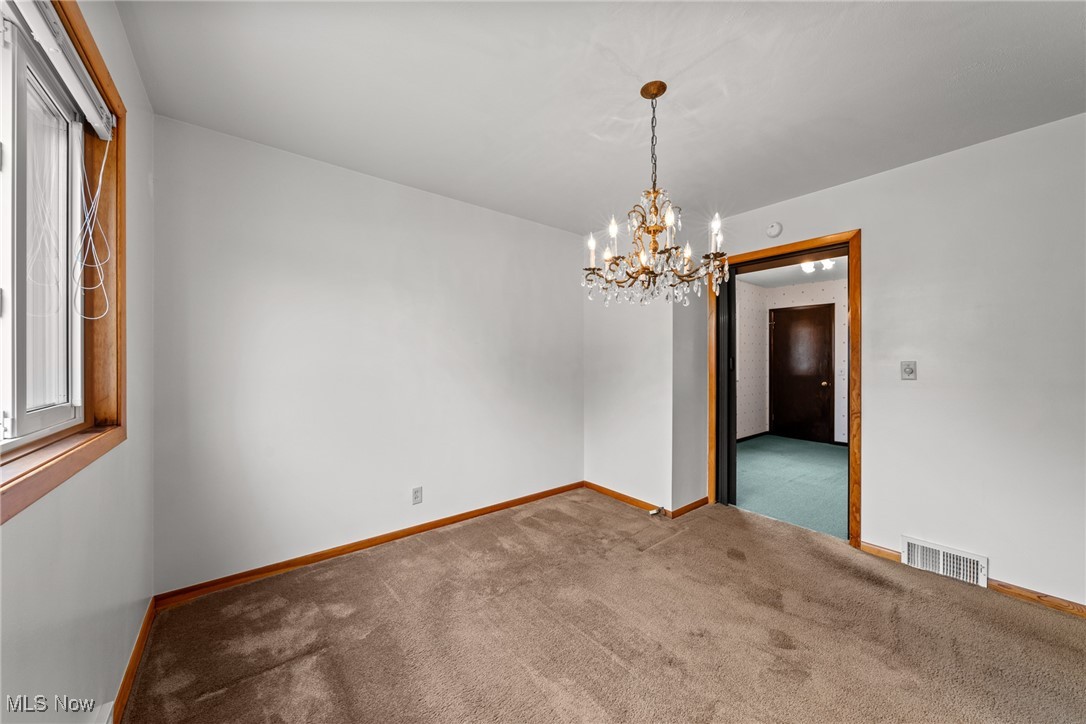 29776 Arthur Road Wickliffe, OH 44092 - Photo 8 of 49 Unfurnished room with a chandelier, carpet floors, and plenty of natural light