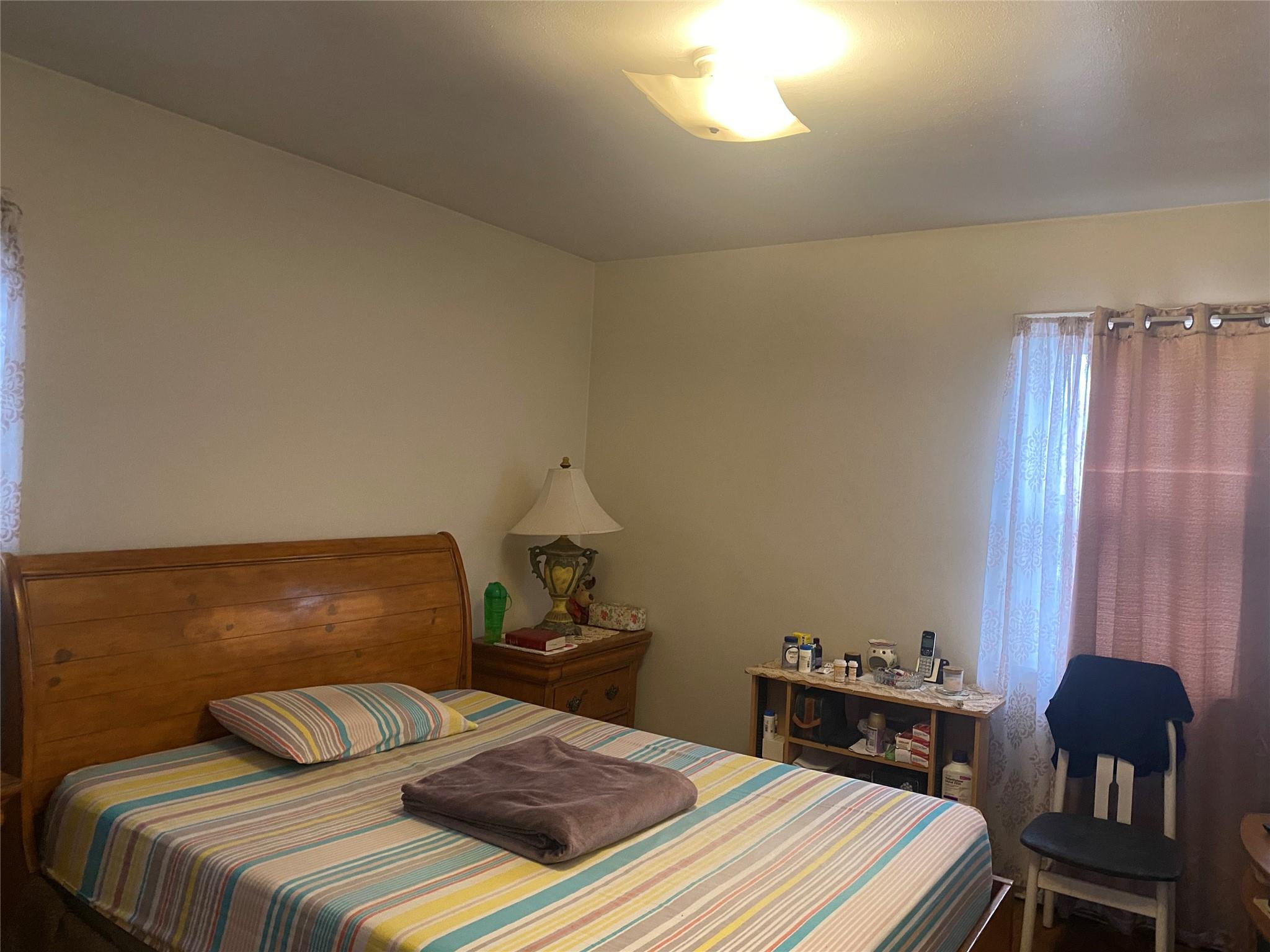 106-60 Ditmars Boulevard Queens, NY 11369 - Photo 4 of 12 a bedroom with a bed and window