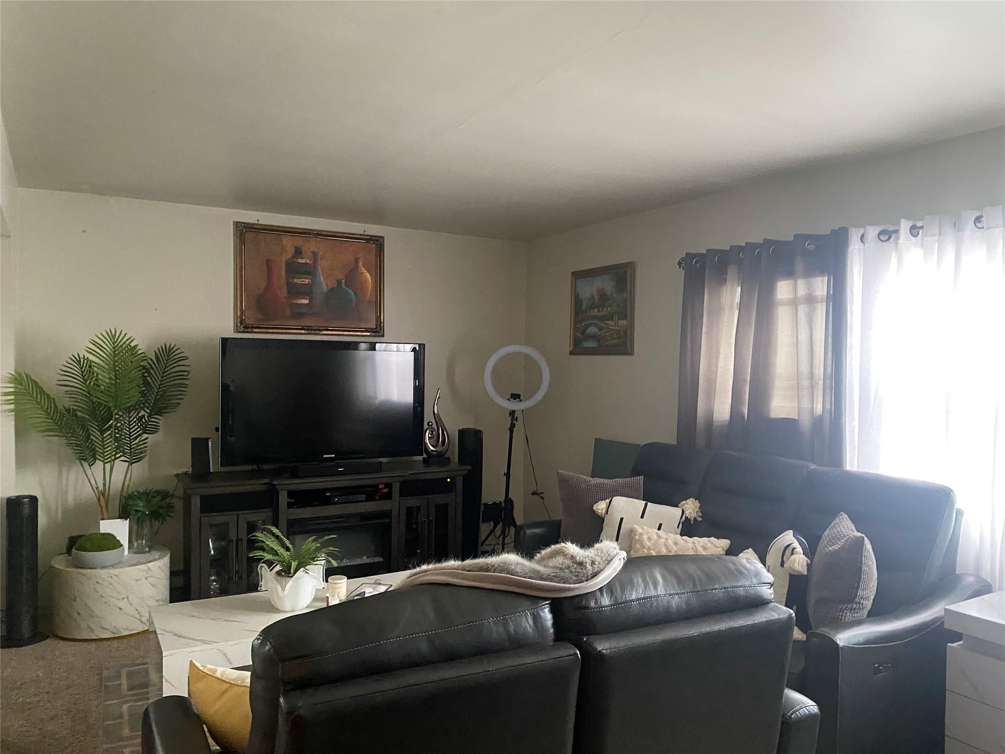 106-60 Ditmars Boulevard Queens, NY 11369 - Photo 6 of 12 a living room with furniture and a flat screen tv