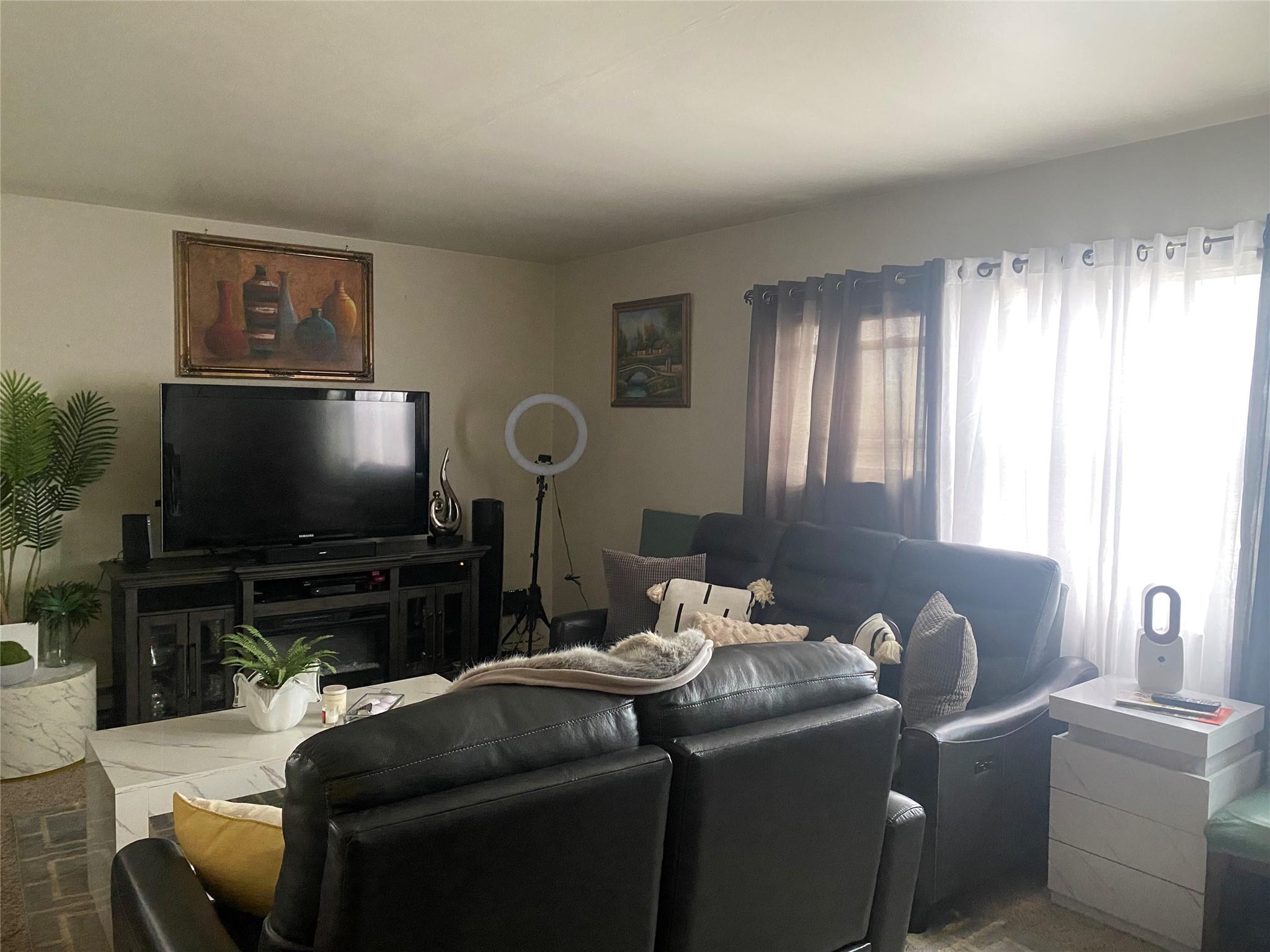 106-60 Ditmars Boulevard Queens, NY 11369 - Photo 8 of 12 a living room with furniture and a flat screen tv