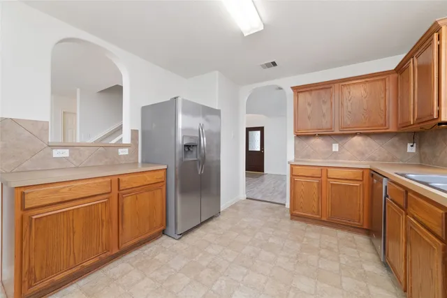 a kitchen with stainless steel appliances granite countertop a refrigerator and cabinets
