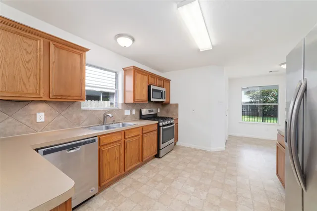 a kitchen with stainless steel appliances granite countertop a stove a sink and a refrigerator
