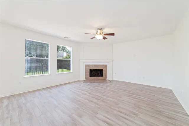 a view of an empty room with a fireplace and a window
