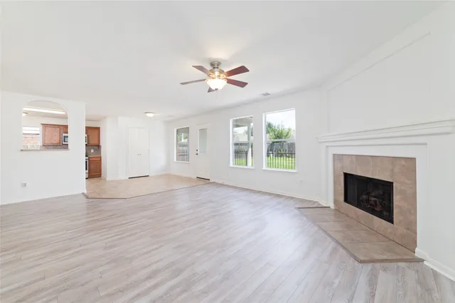 an empty room with windows fireplace and a sink