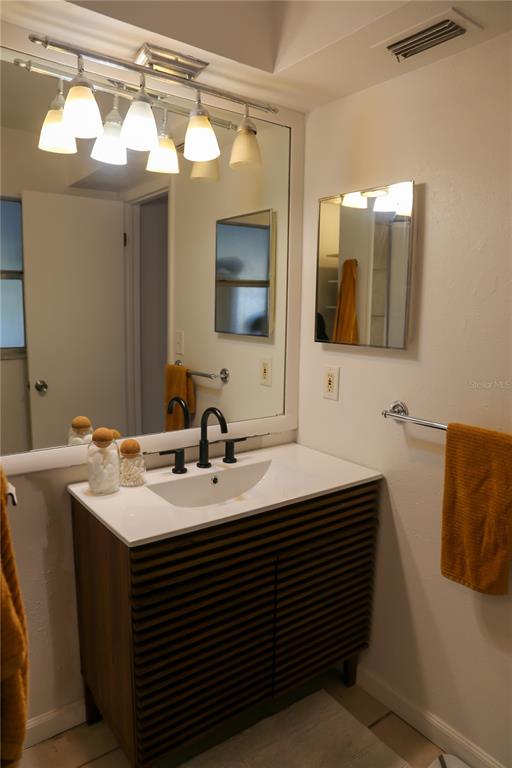 1810 Copper Kettle Lane Dunedin, FL 34698 - Photo 16 of 22 a bathroom with a sink and a mirror