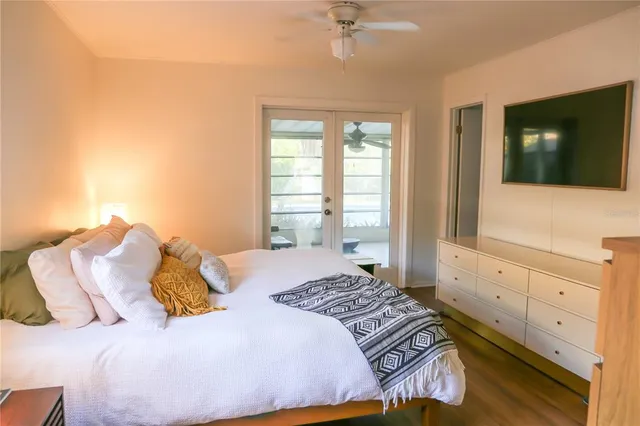a bedroom with a large bed and a flat tv screen on dresser