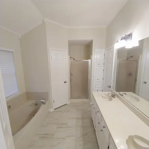 a spacious bathroom with a tub sink and mirror