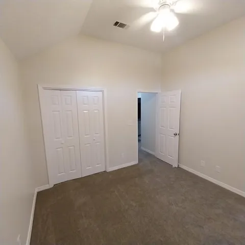 an empty room with a chandelier fan