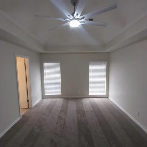 a view of empty room with window and a ceiling fan