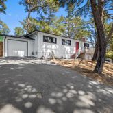 a view of a house with backyard and trees