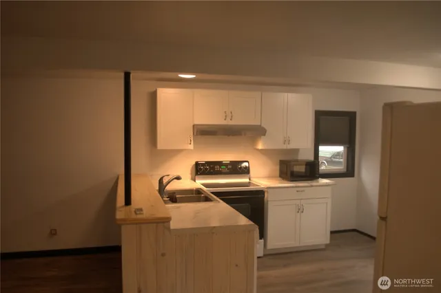 a kitchen with a sink a stove and cabinets