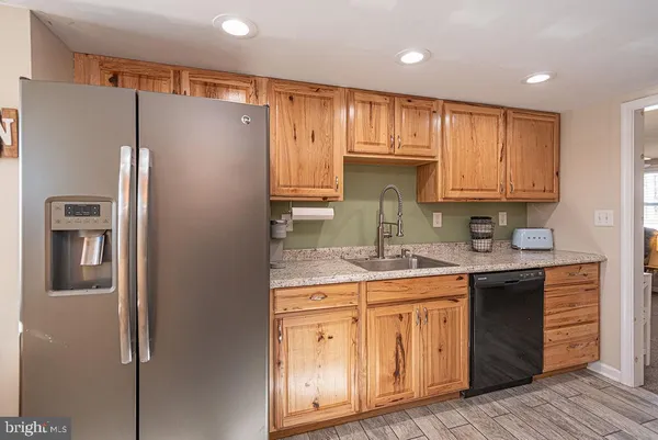 a kitchen with stainless steel appliances granite countertop a refrigerator and a stove