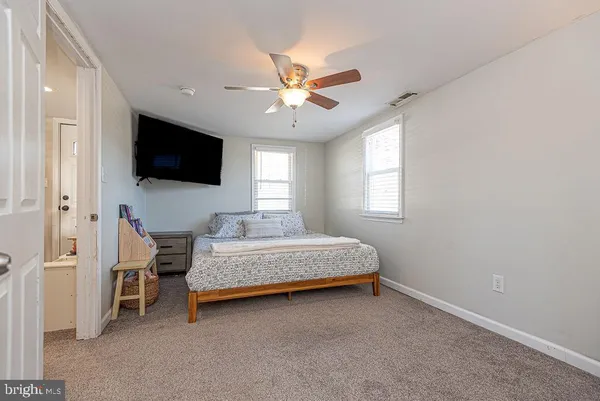 a bedroom with a bed a flat screen tv and a window