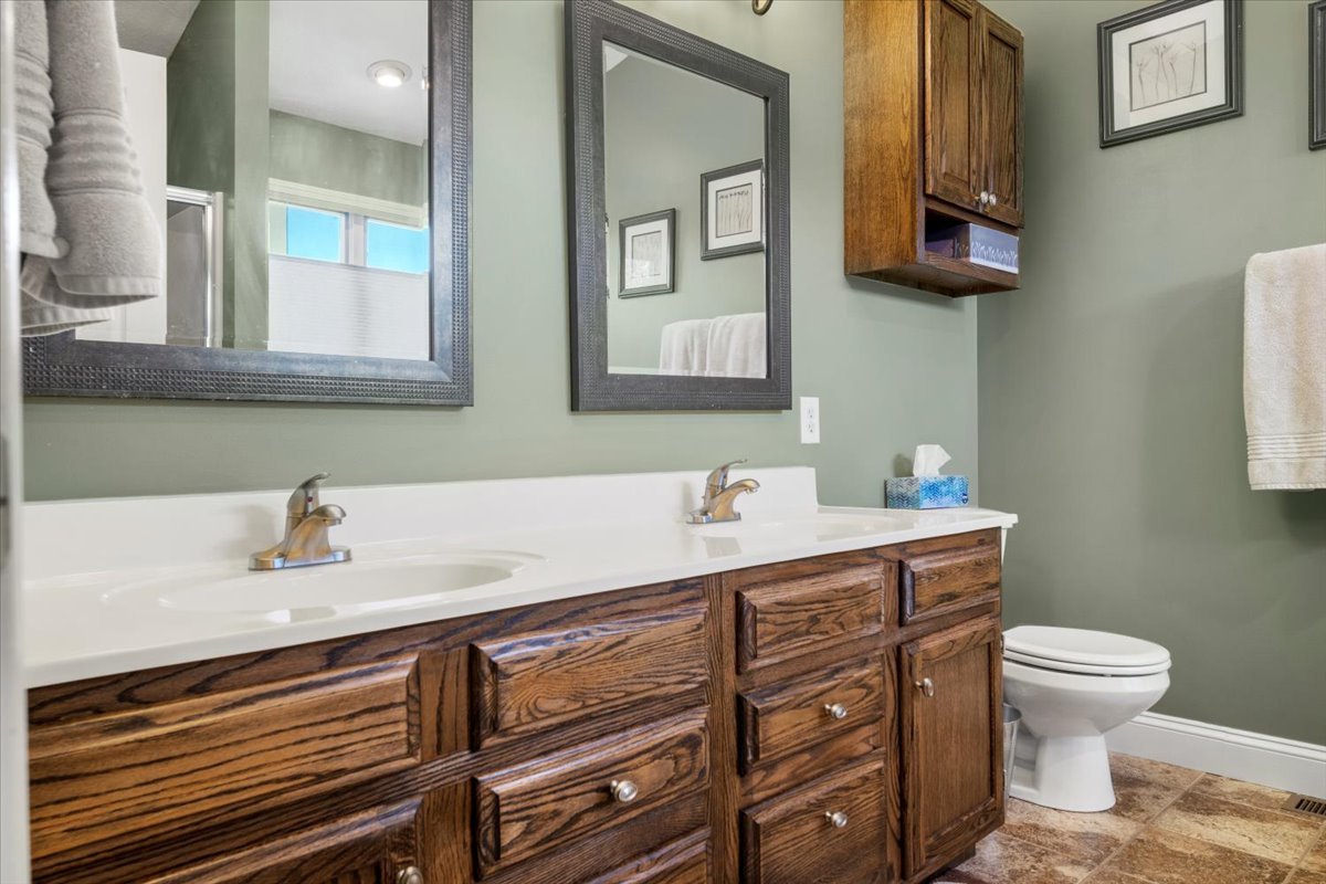3215 Eagle Crest Road Bloomington, IL 61704 - Photo 24 of 35 a bathroom with a sink a toilet and mirror