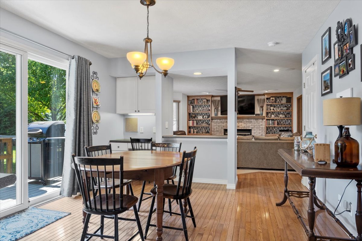 3215 Eagle Crest Road Bloomington, IL 61704 - Photo 9 of 35 a view of a dining room and livingroom with furniture wooden floor a chandelier