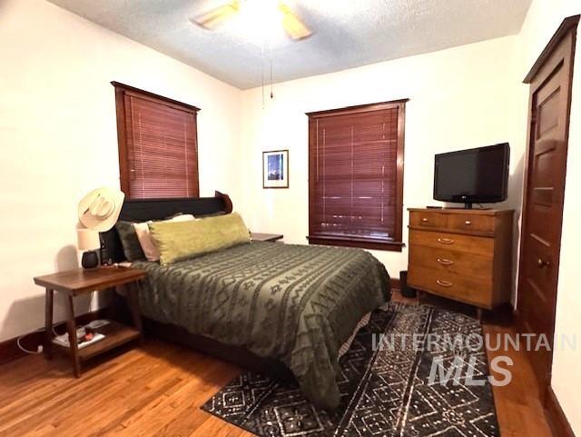 450 South 3rd E Street Mountain Home, ID 83647 - Photo 17 of 35 Bedroom with wood finished floors, a textured ceiling, and ceiling fan