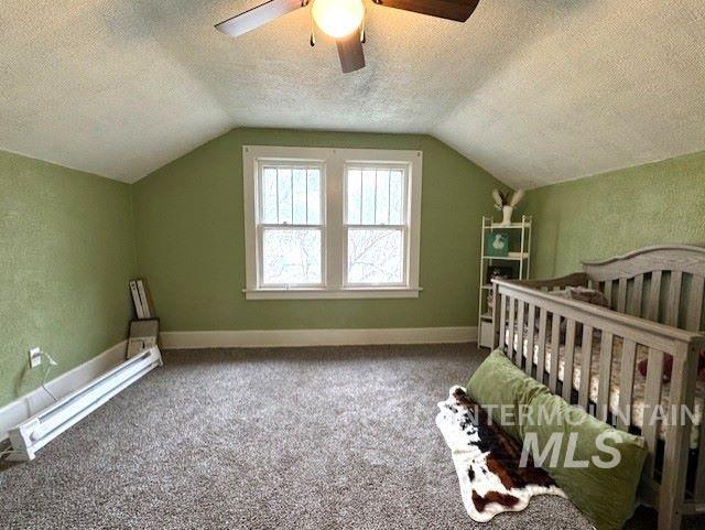 450 South 3rd E Street Mountain Home, ID 83647 - Photo 29 of 35 Unfurnished bedroom featuring a crib, a textured ceiling, a baseboard heating unit, carpet, and a ceiling fan