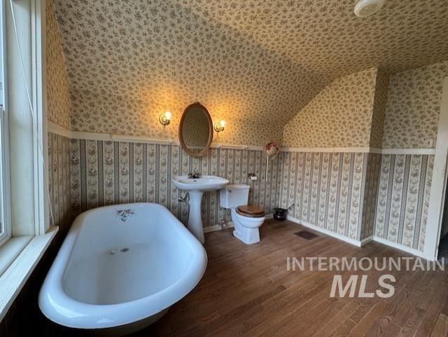 450 South 3rd E Street Mountain Home, ID 83647 - Photo 31 of 35 Bathroom featuring hardwood / wood-style flooring, lofted ceiling, a freestanding tub, and wallpapered walls