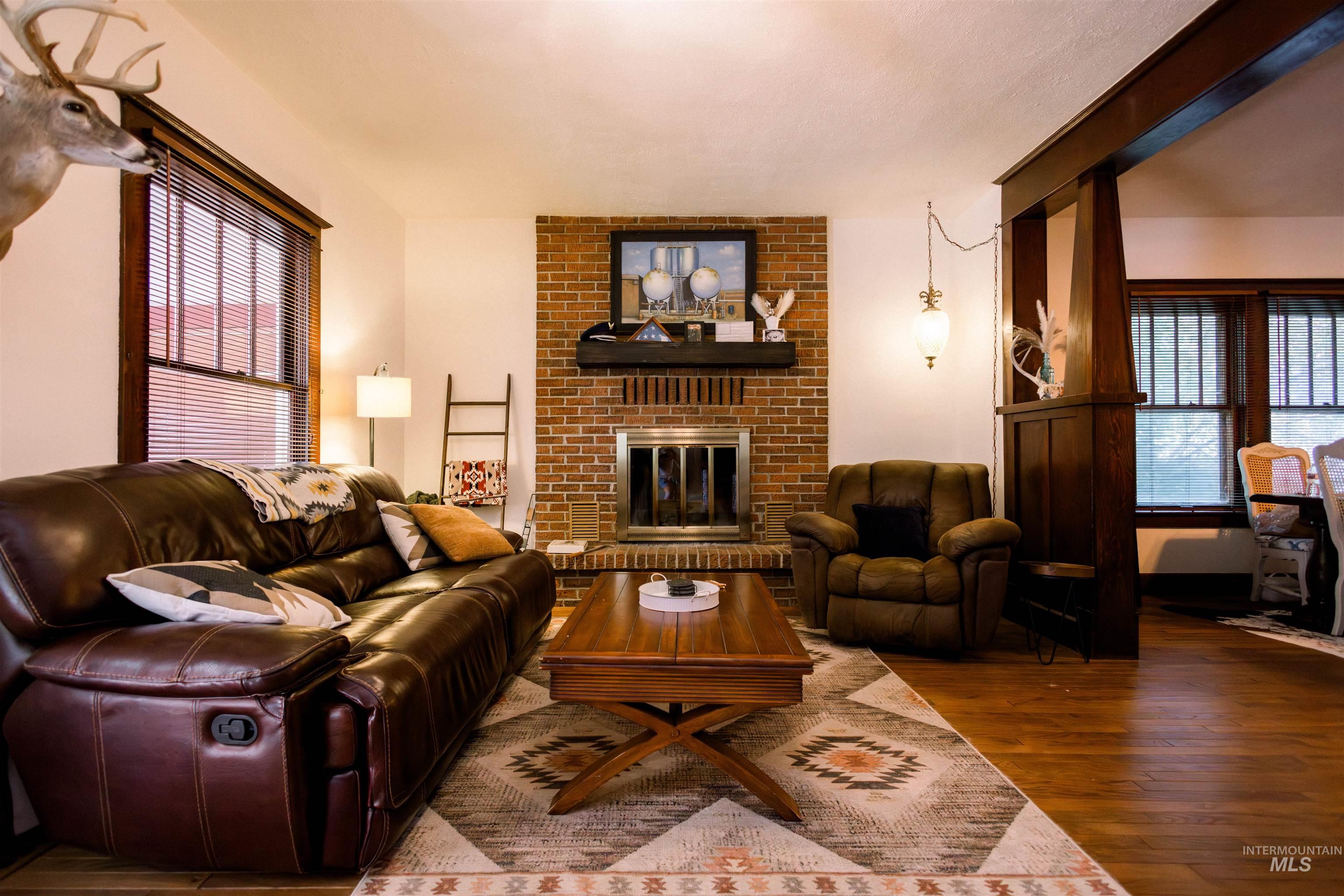 450 South 3rd E Street Mountain Home, ID 83647 - Photo 4 of 35 Living area featuring wood finished floors and a brick fireplace