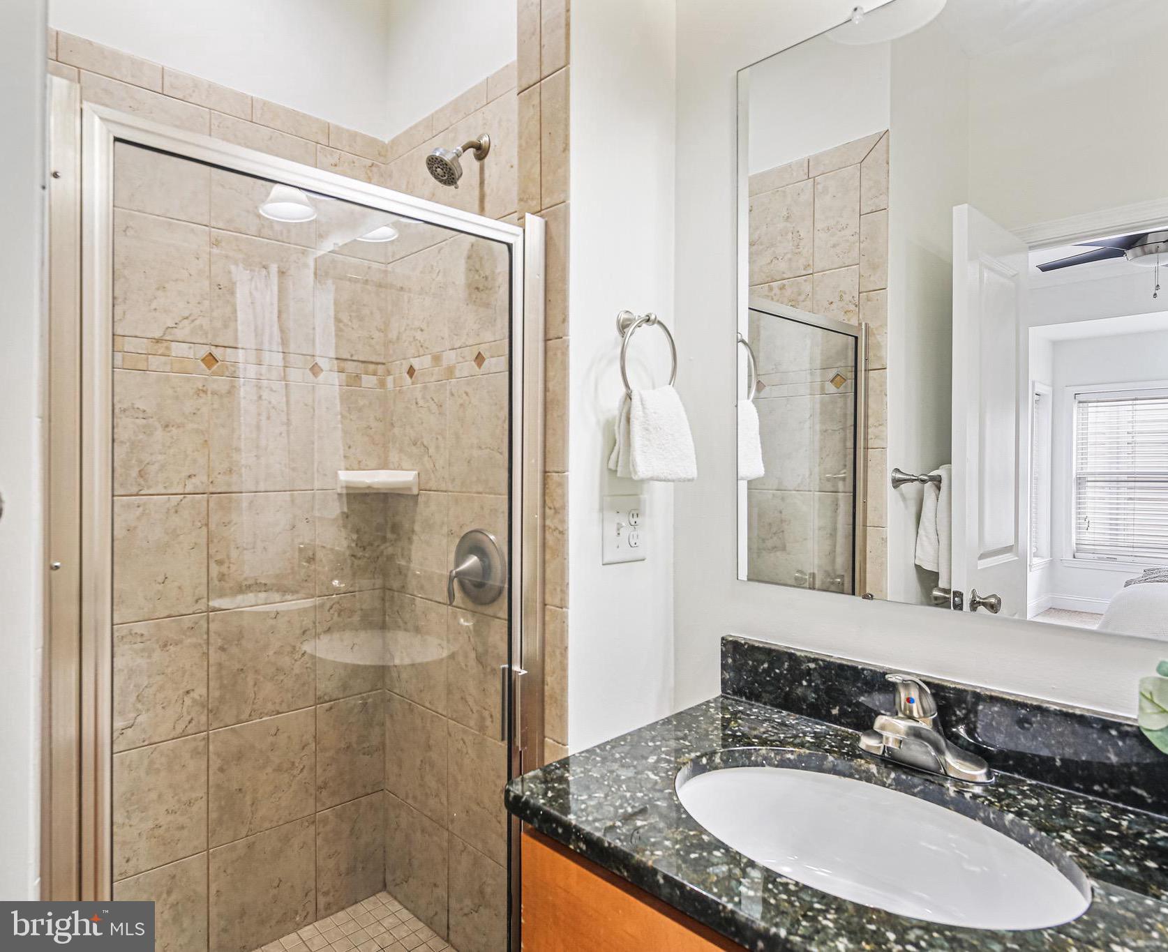 3418 Gunther Way Baltimore, MD 21224 - Photo 25 of 57 a bathroom with a granite countertop double vanity sink mirror and shower