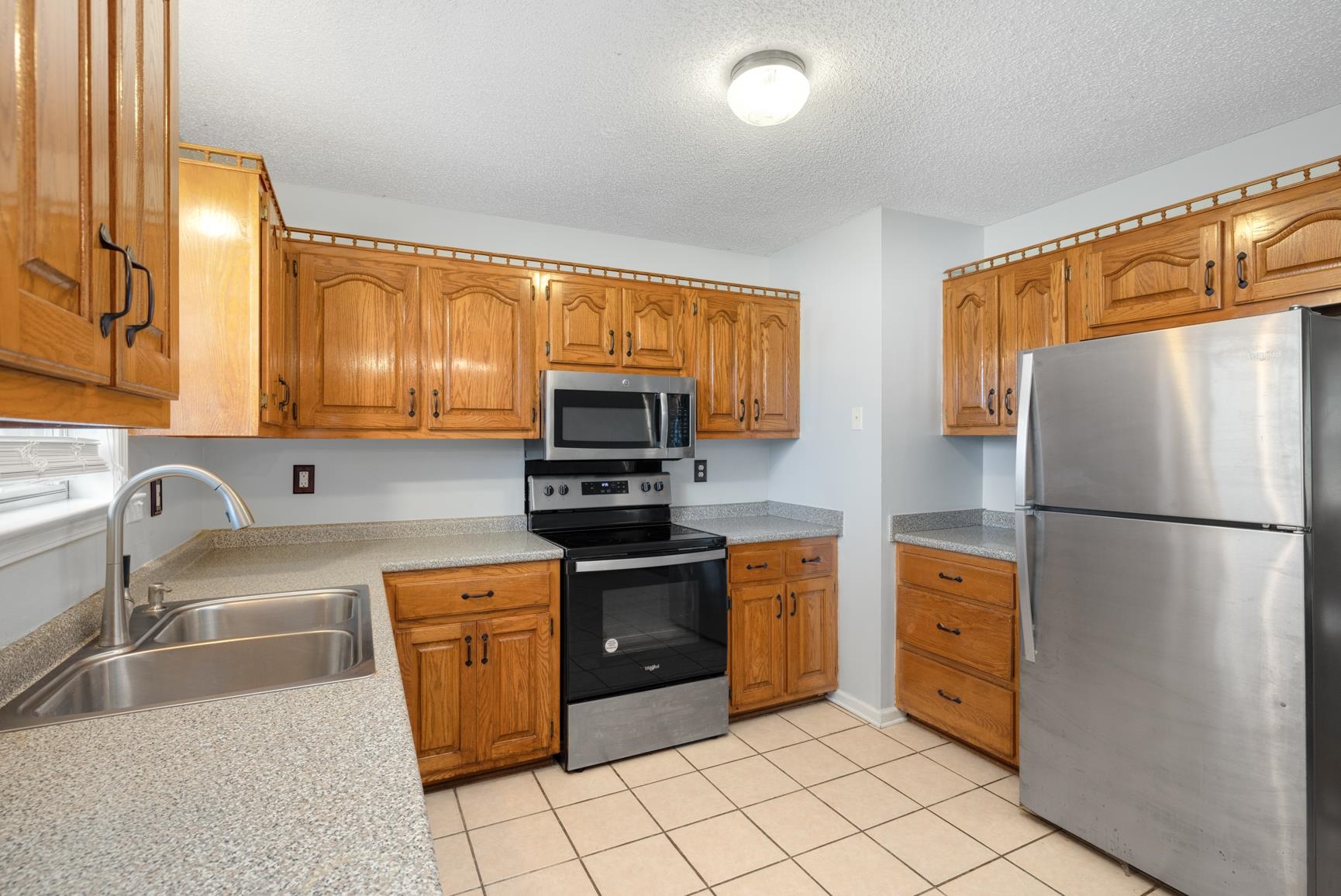 5305 Portersville Road Atoka, TN 38004 - Photo 9 of 20 Kitchen with appliances with stainless steel finishes, a textured ceiling, light tile patterned floors, and sink
