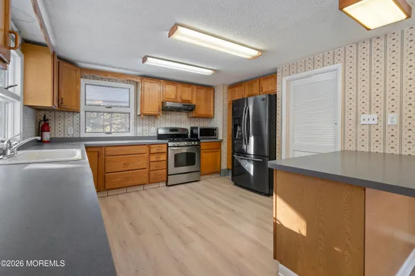 an empty room with wooden floor and chandelier fan