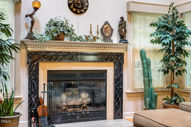 a living room with a fireplace and potted plants