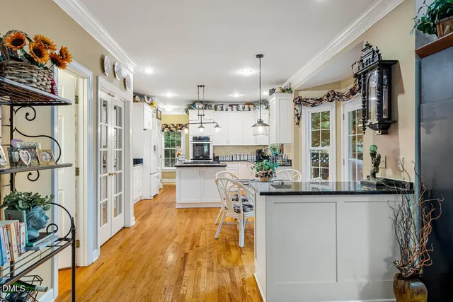 a kitchen with stainless steel appliances granite countertop a refrigerator a sink and wooden floors