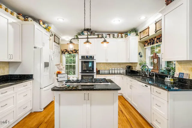 a kitchen with granite countertop a sink stainless steel appliances and cabinets