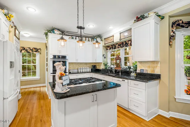 a kitchen with granite countertop a sink stove and cabinets