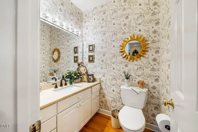 a bathroom with a sink mirror vanity and toilet