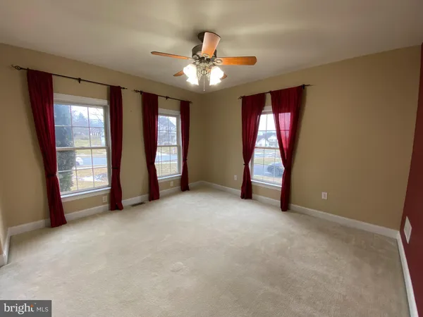 a view of an empty room with window and stairs