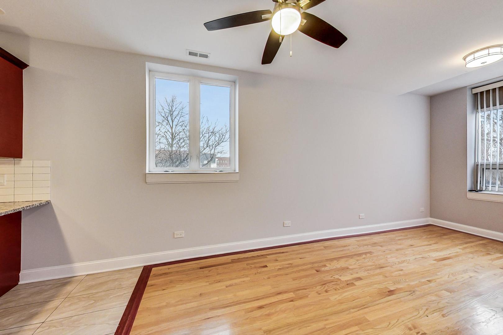 2325 West Taylor Street, Unit 2 Chicago, IL 60612 - Photo 4 of 19 a view of an empty room with wooden floor and a window