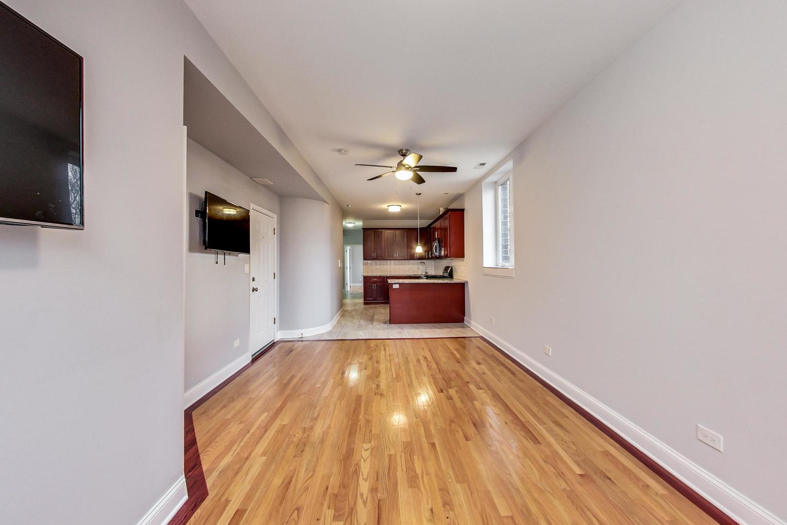 2325 West Taylor Street, Unit 2 Chicago, IL 60612 - Photo 5 of 19 a view of a hallway with wooden floor and a flat screen tv