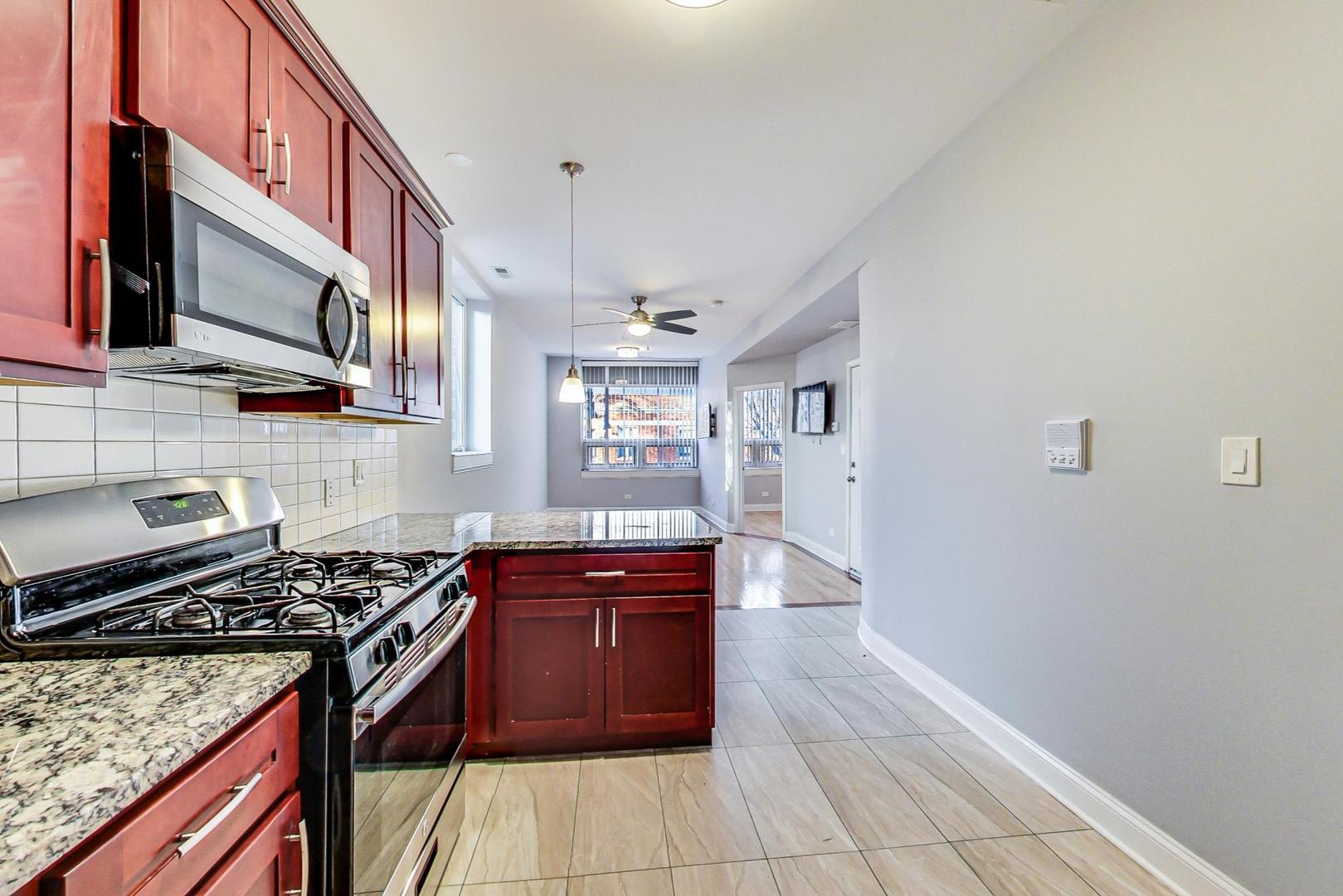 2325 West Taylor Street, Unit 2 Chicago, IL 60612 - Photo 7 of 19 a kitchen with stainless steel appliances granite countertop a stove and a microwave