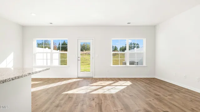 a view of a bedroom with wooden floor and a window