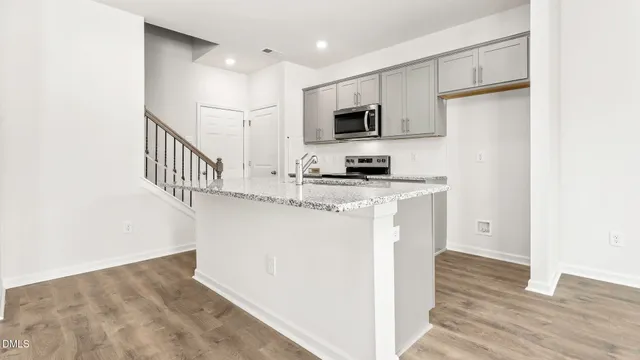 a kitchen with stainless steel appliances a refrigerator a stove a microwave and cabinets